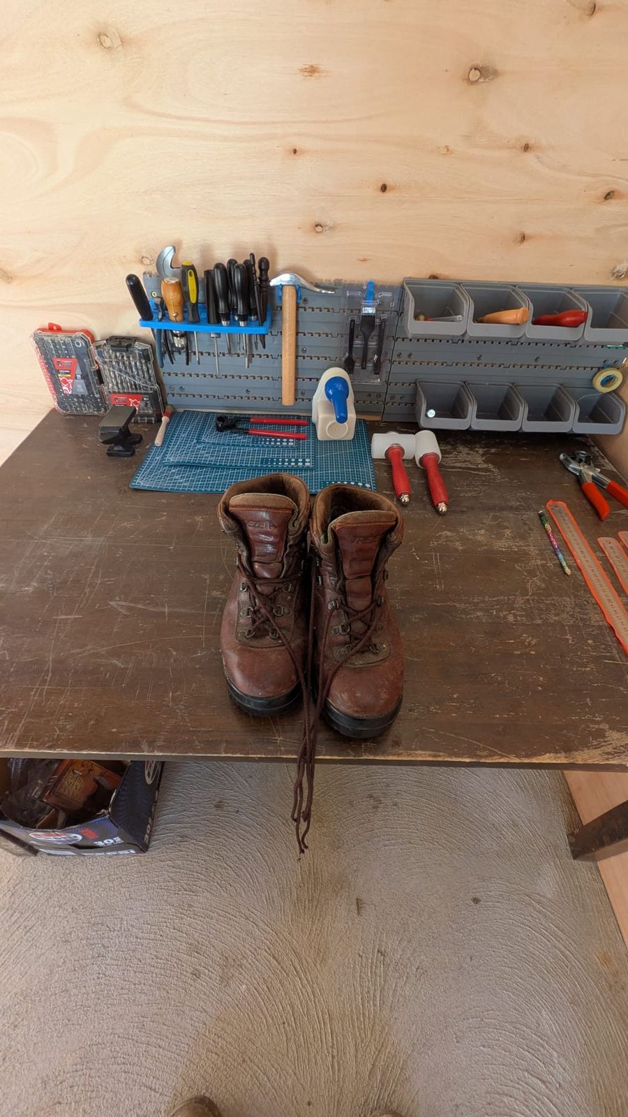 The workshop bench at Blackwood — hand tools racked on the wall, a worn pair of hiking boots waiting on the bench top